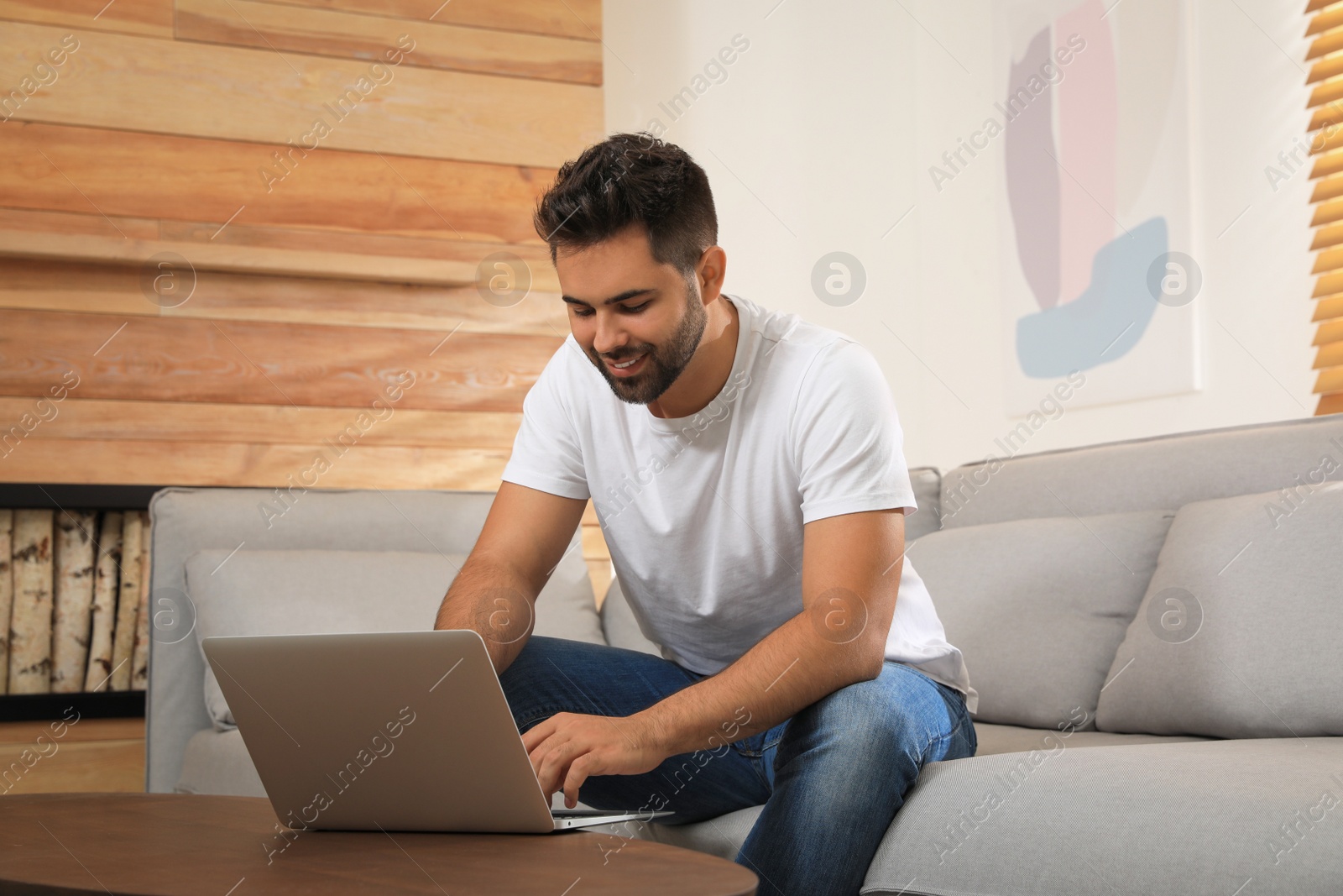 Photo of Man using laptop for online shopping at home