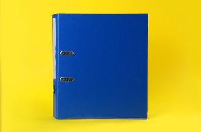 Photo of Blue hardcover office folder on yellow background