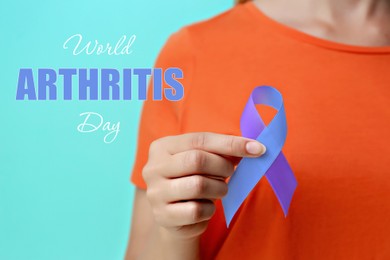 Image of World Arthritis Day. Woman with blue and purple awareness ribbon on color background, closeup