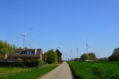 Photo of Beautiful view of countryside with wind turbines on sunny day. Alternative energy source