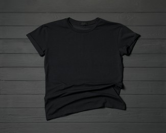 Stylish black T-shirt on gray wooden table, top view