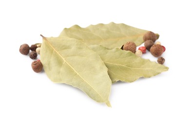 Photo of Aromatic bay leaves and peppercorns on white background