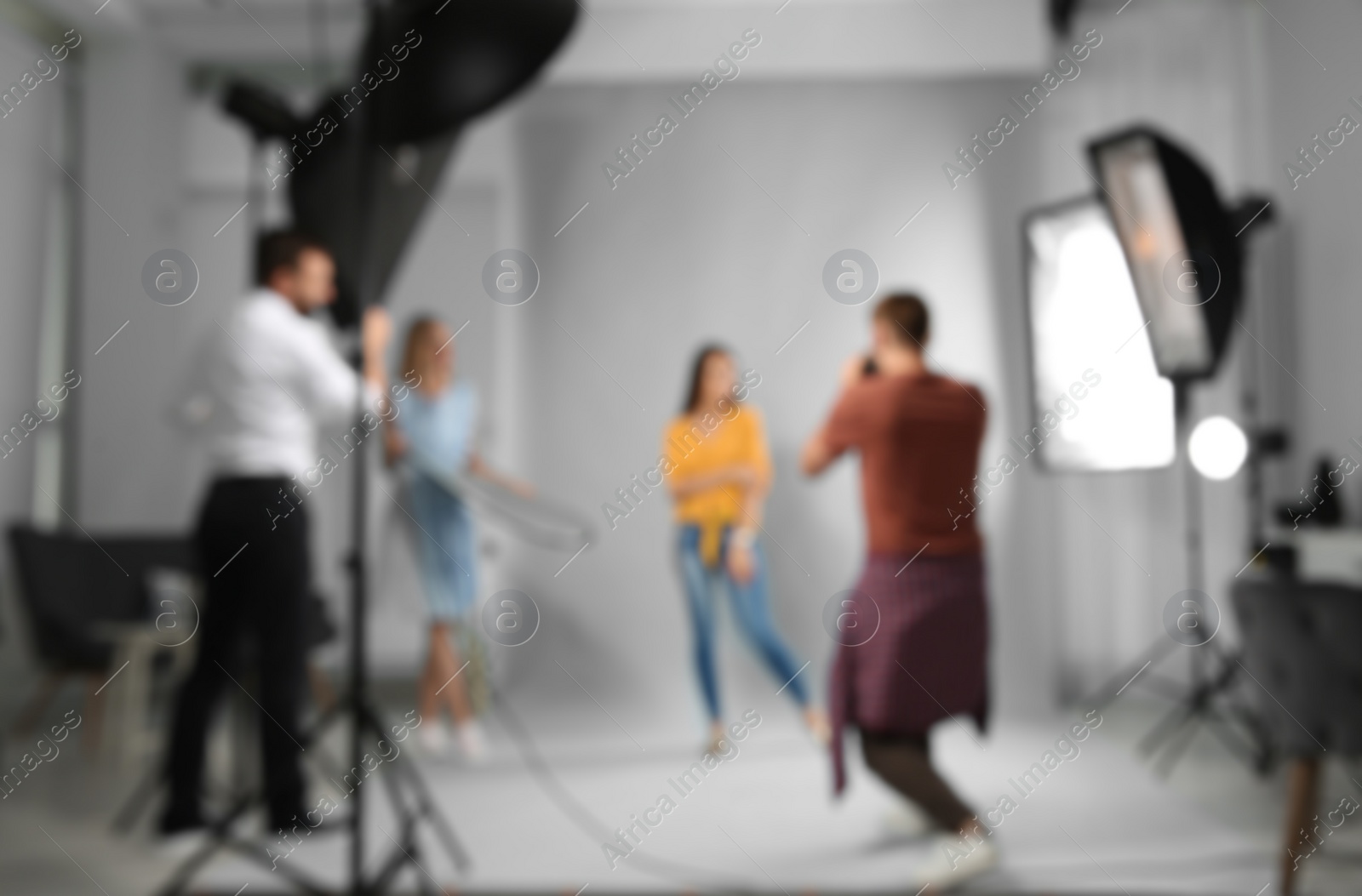 Photo of Blurred view of professional team working with model in photo studio