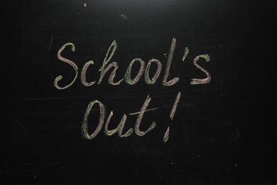 Photo of Text SCHOOL'S OUT written on blackboard. Summer holidays