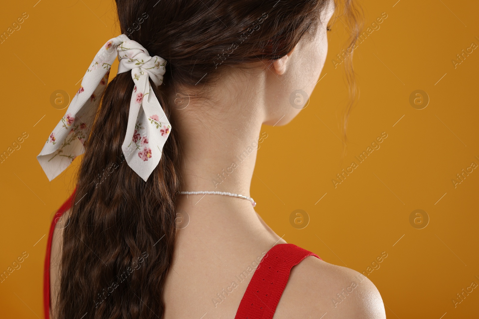 Photo of Woman with stylish bandana on yellow background, closeup