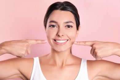 Young woman with healthy teeth on color background