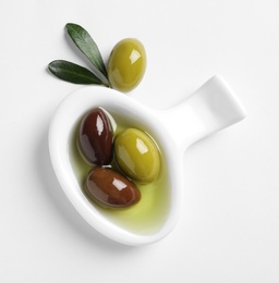 Bowl with fresh olives in oil on white background, top view