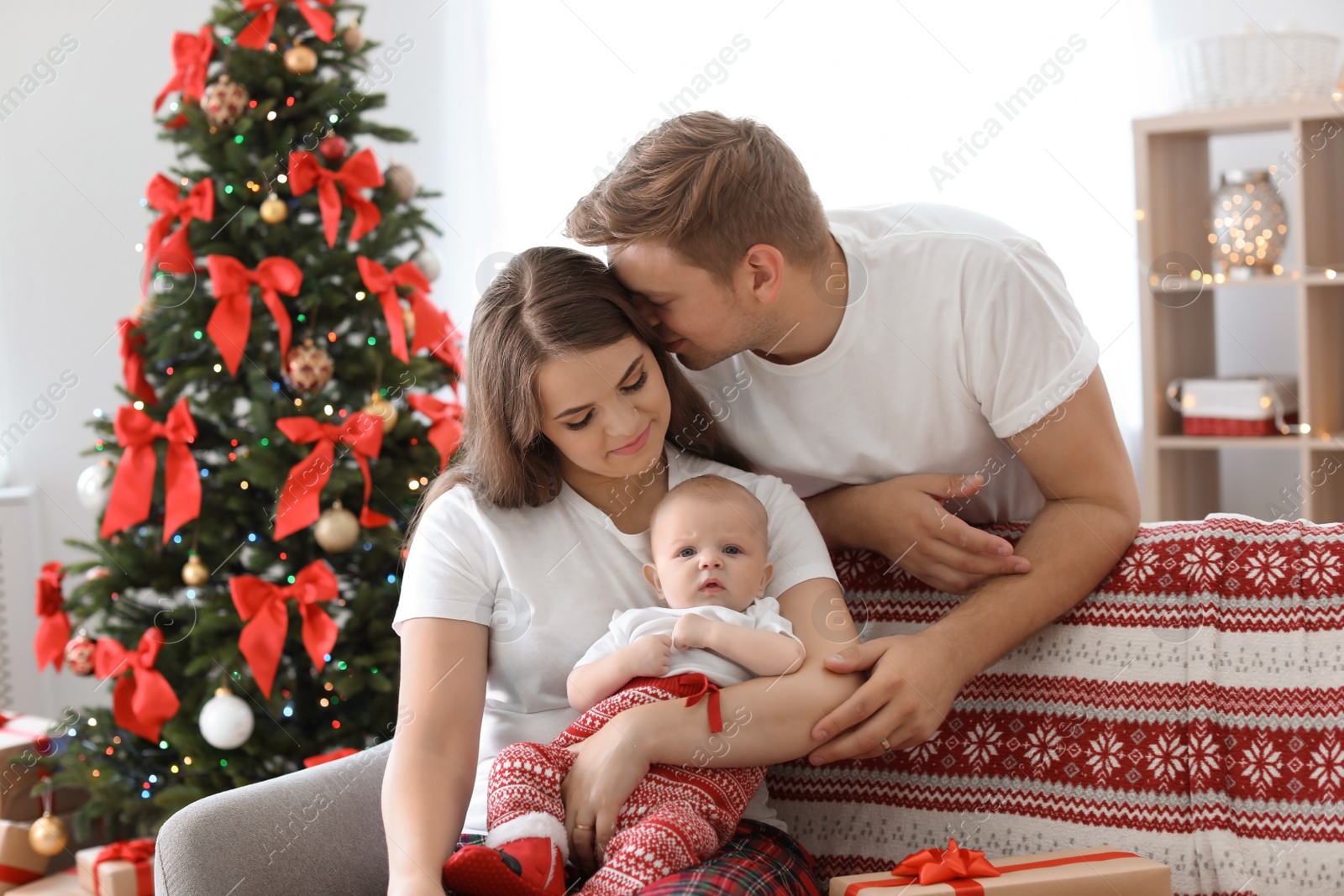 Photo of Happy couple with baby celebrating Christmas together at home