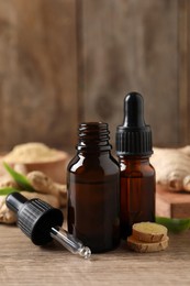 Ginger essential oil in bottles on wooden table