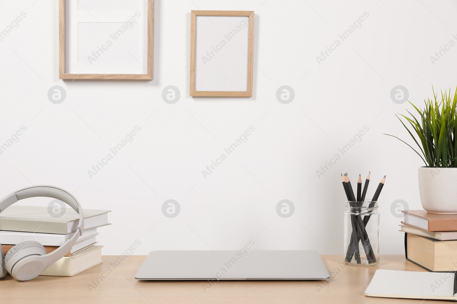 Photo of Cozy workspace with laptop and stationery on wooden desk at home