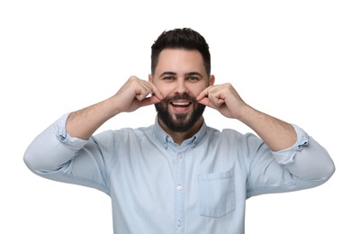 Happy young man touching mustache on white background
