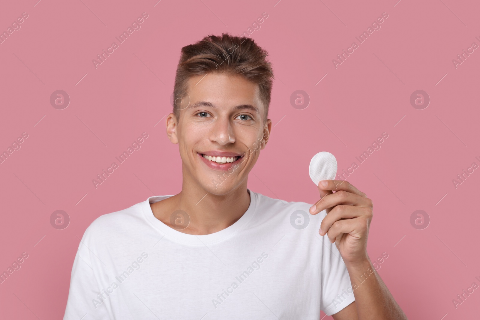 Photo of Handsome man with cotton pad on pink background