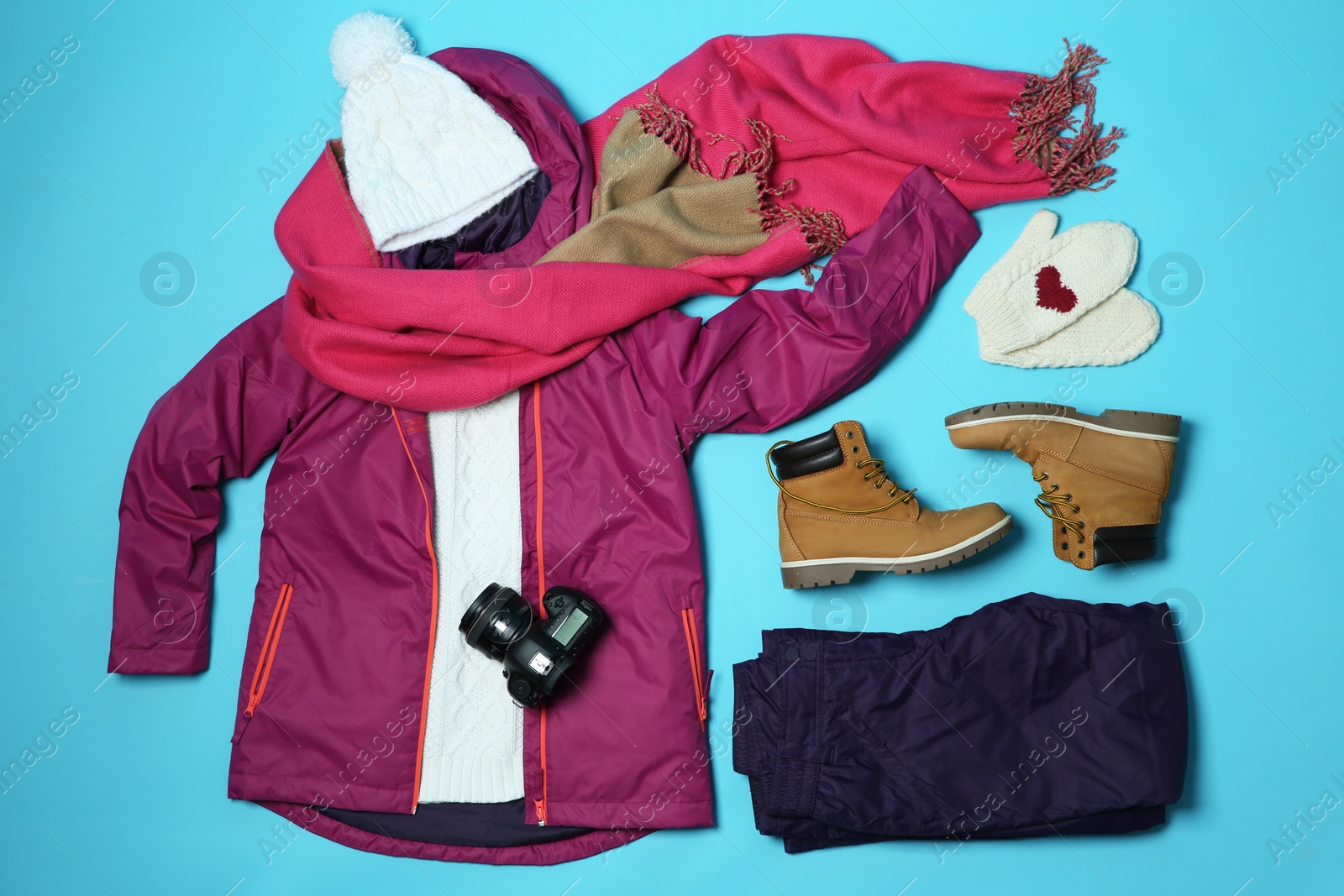 Photo of Flat lay composition with warm clothes for winter vacation on color background