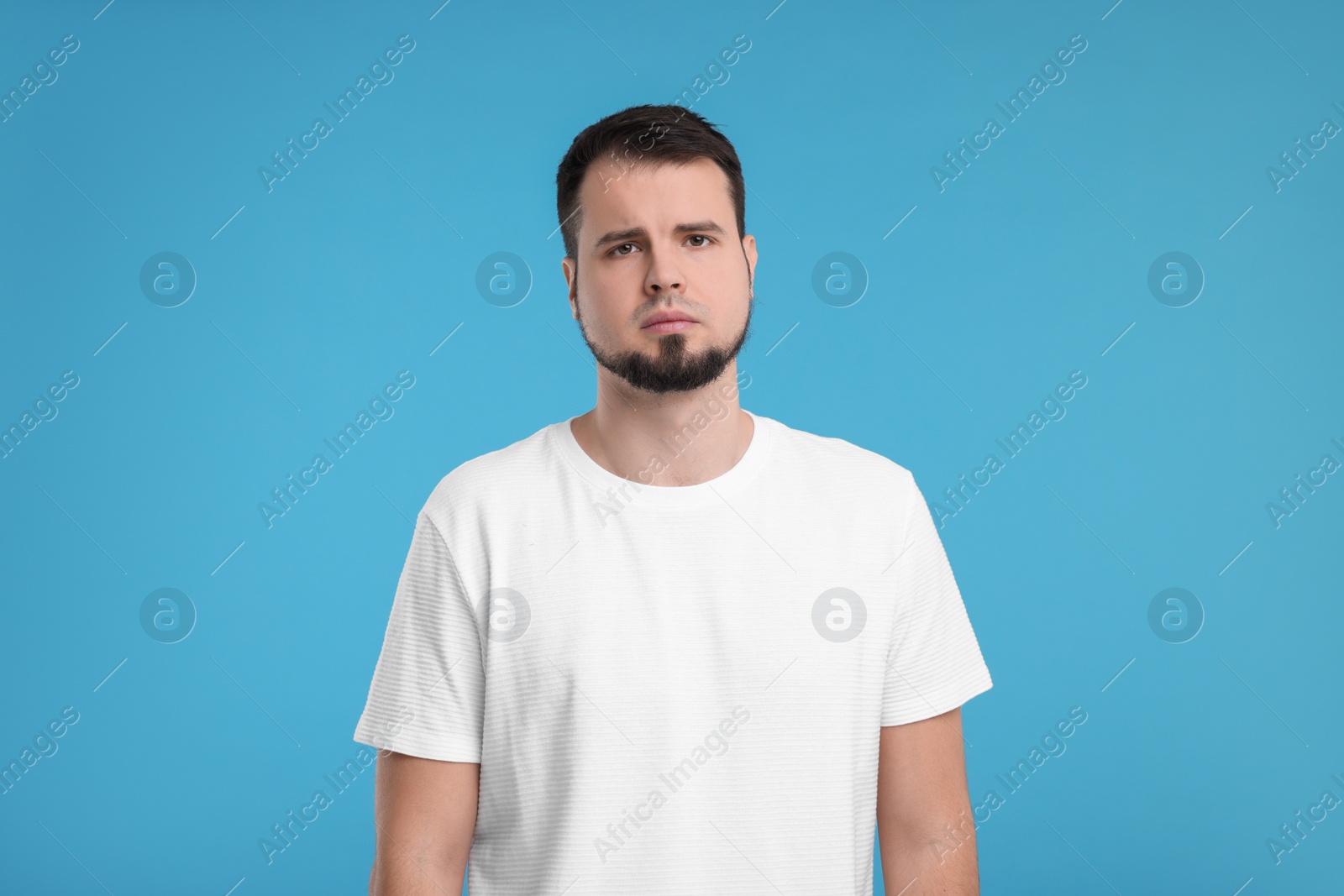 Photo of Portrait of sad man on light blue background