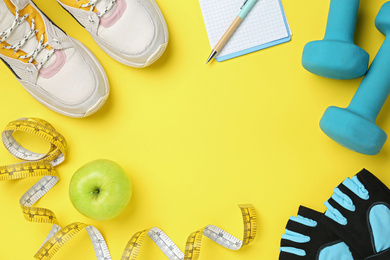 Flat lay composition with sport items on yellow background. Space for text