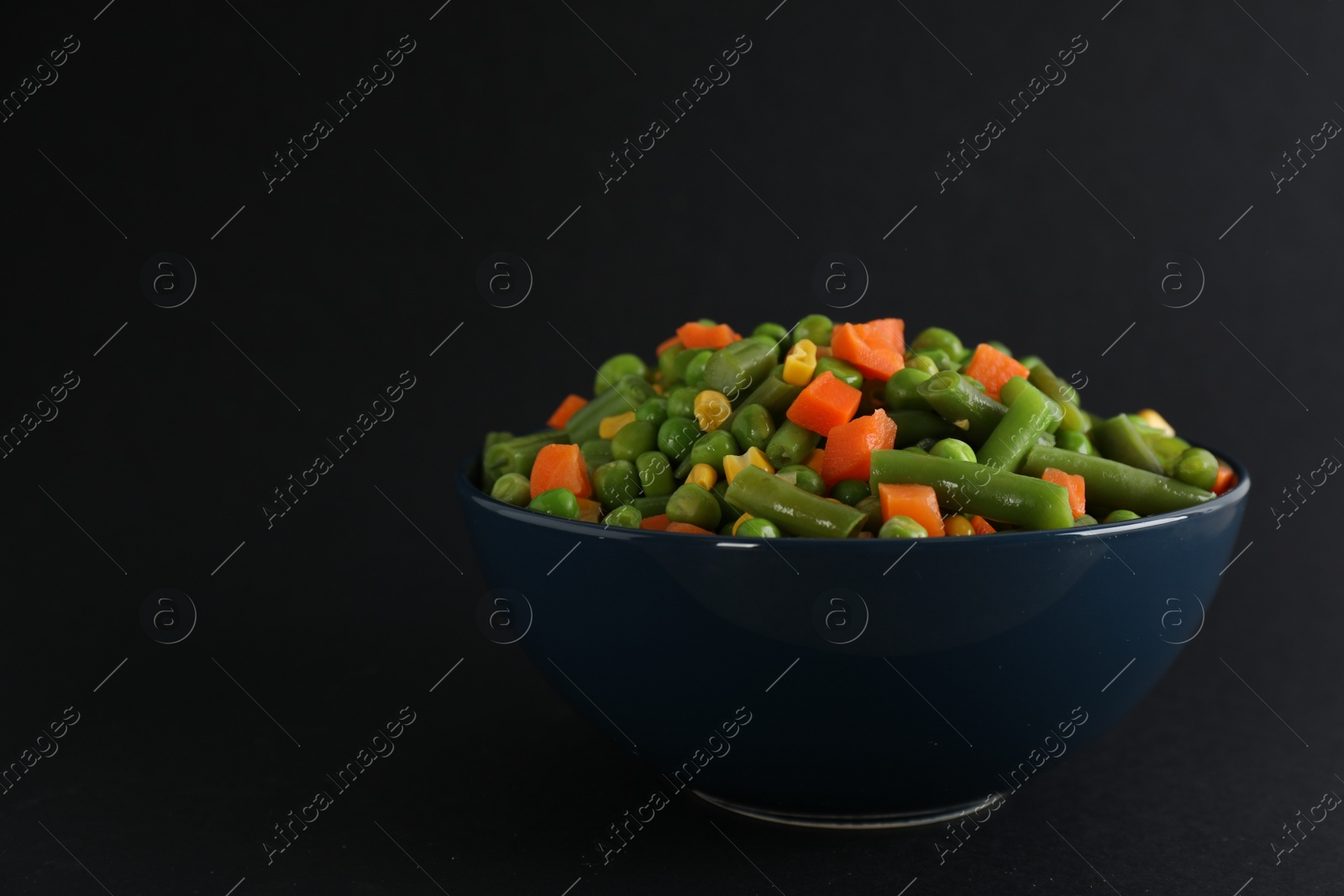 Photo of Mix of fresh vegetables in bowl on black background. Space for text