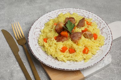 Photo of Delicious pilaf with meat served on light grey table
