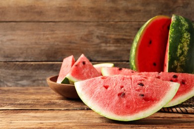 Photo of Delicious fresh watermelon slices on wooden table. Space for text