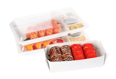 Photo of Food delivery. Containers with different delicious sushi rolls on white background