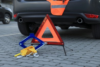Photo of Emergency warning triangle and safety equipment near car