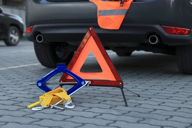 Emergency warning triangle and safety equipment near car