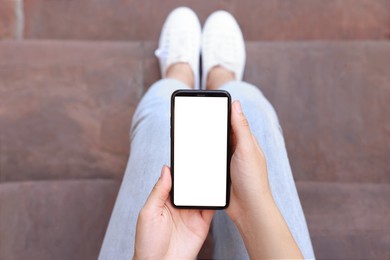 Closeup of woman using smartphone outdoors, top view