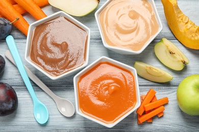 Healthy baby food and ingredients on grey wooden table, flat lay