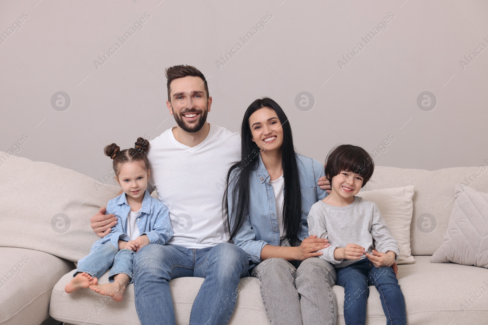 Photo of Portrait of happy family on sofa in living room