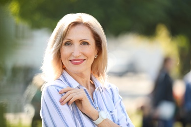 Portrait of happy mature woman in park on sunny day