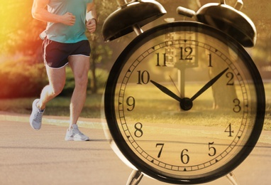 Time to do morning exercises. Double exposure of man running in park and alarm clock