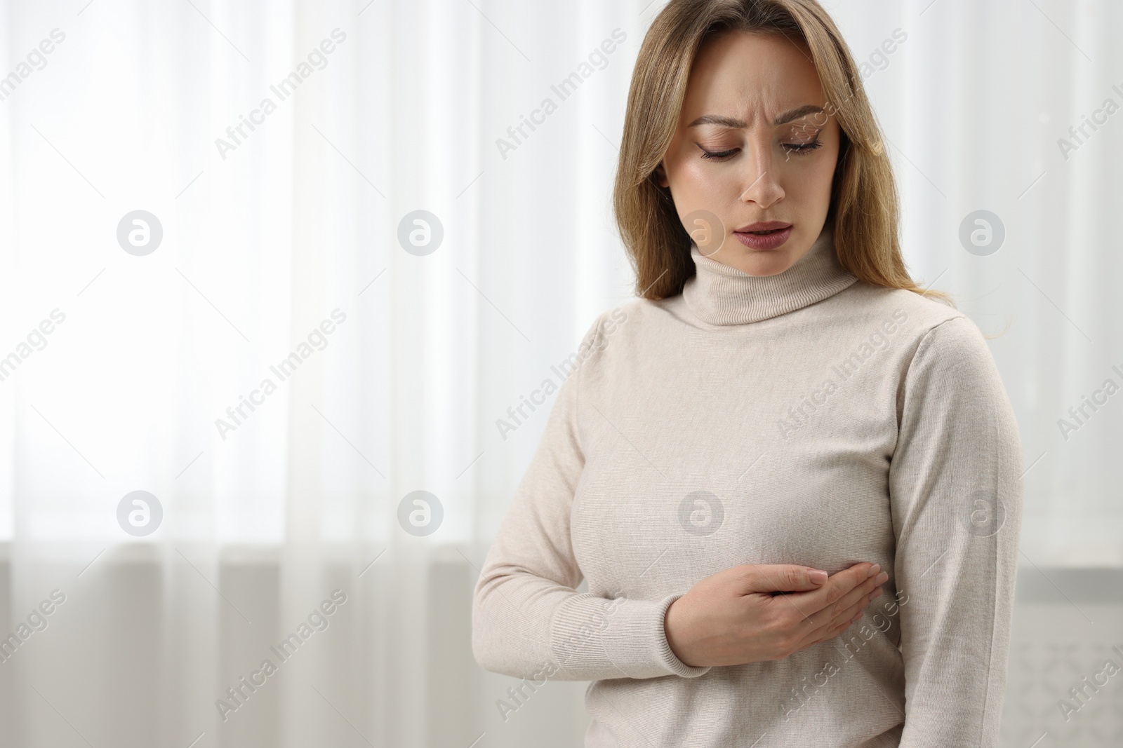 Photo of Mammology. Young woman doing breast self-examination at home