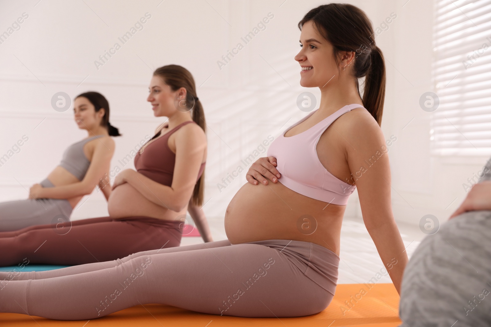 Photo of Group of pregnant women doing exercises in gym. Preparation for child birth