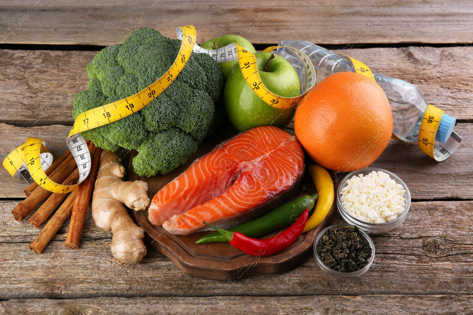 Photo of Metabolism. Different food products and measuring tape on wooden table