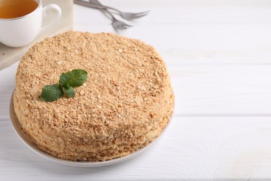 Delicious Napoleon cake served on white wooden table, closeup. Space for text