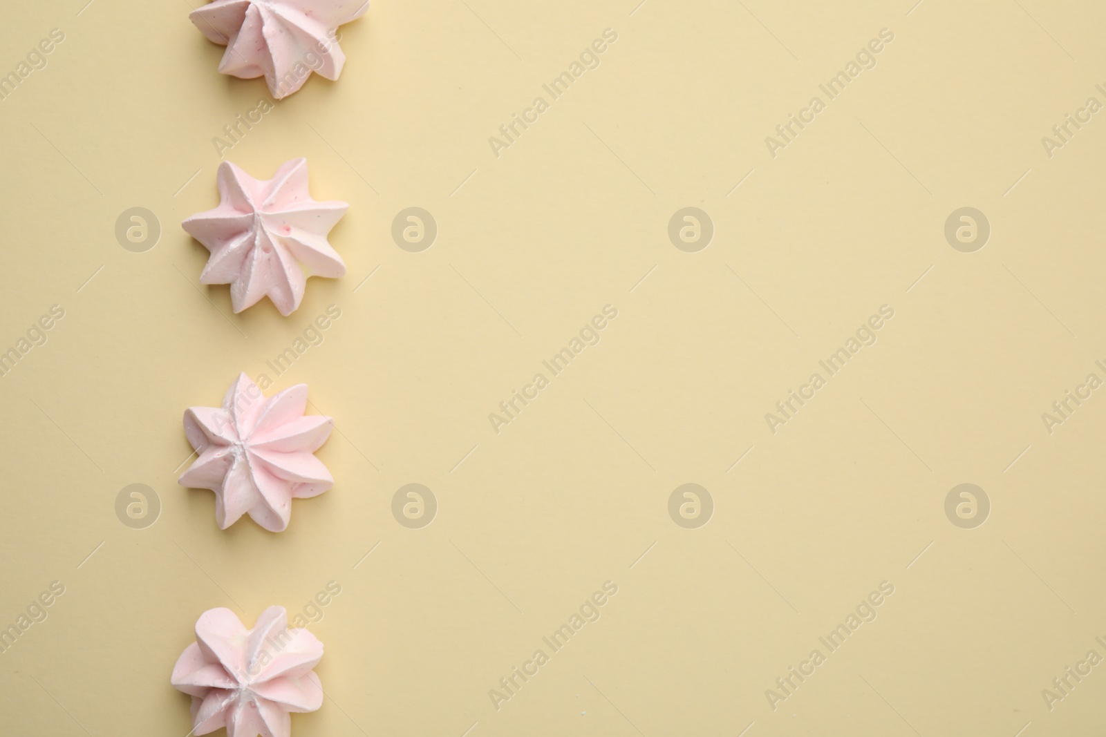 Photo of Delicious meringue cookies on beige background, flat lay. Space for text