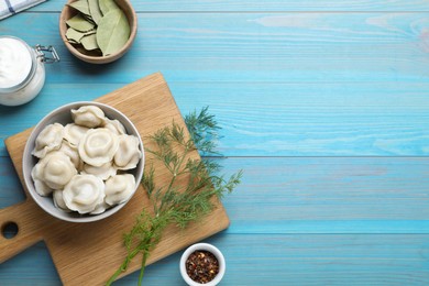 Photo of Delicious dumplings served on turquoise wooden table, flat lay. Space for text