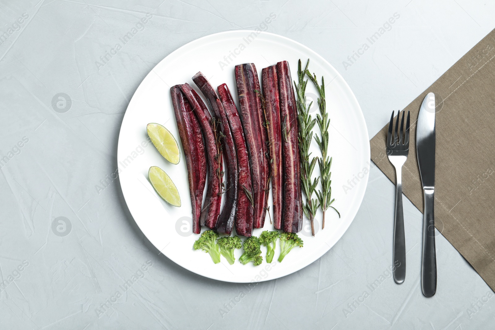 Photo of Flat lay composition with raw black carrot served on light grey table