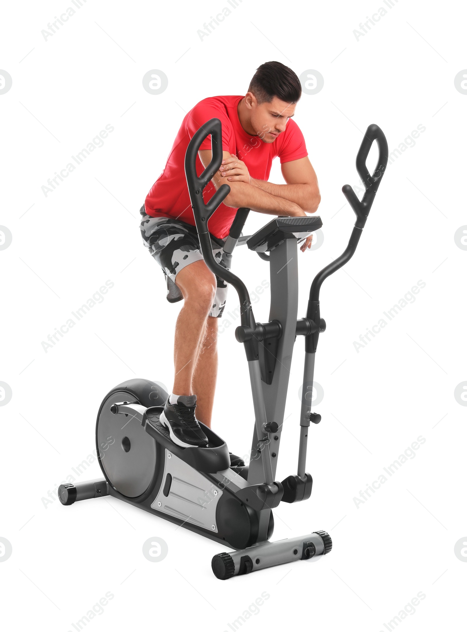 Photo of Tired man after training on modern elliptical machine against white background