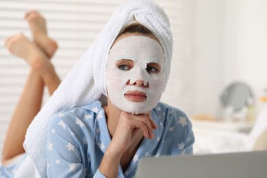 Photo of Young woman with face mask using laptop at home. Spa treatments