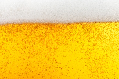 Photo of Glass of tasty beer with foam, closeup