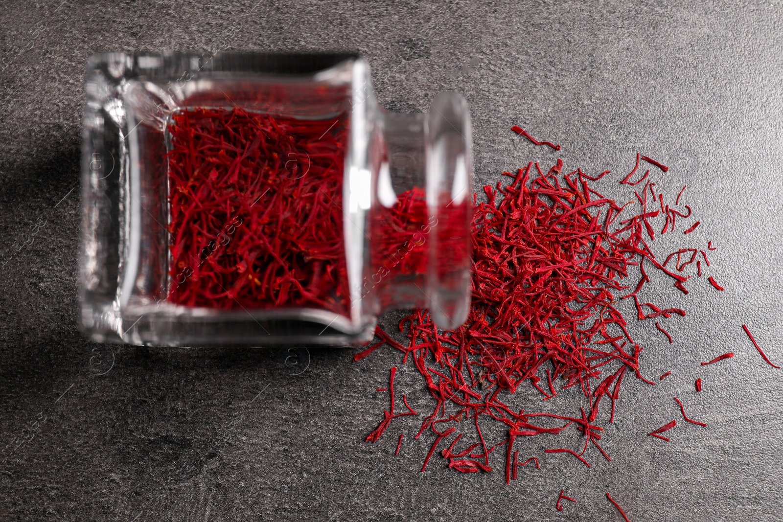 Photo of Aromatic saffron and glass jar on gray table, top view