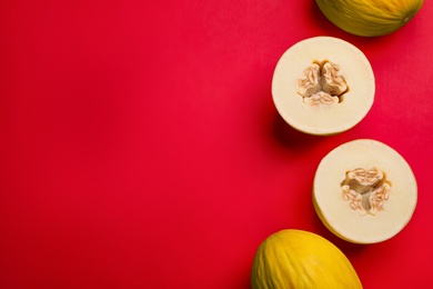 Ripe tasty melons on red background, flat lay. Space for text