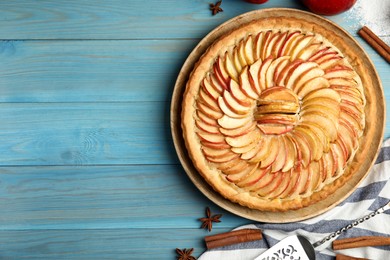 Photo of Flat lay composition with delicious homemade apple tart on light blue wooden table. Space for text