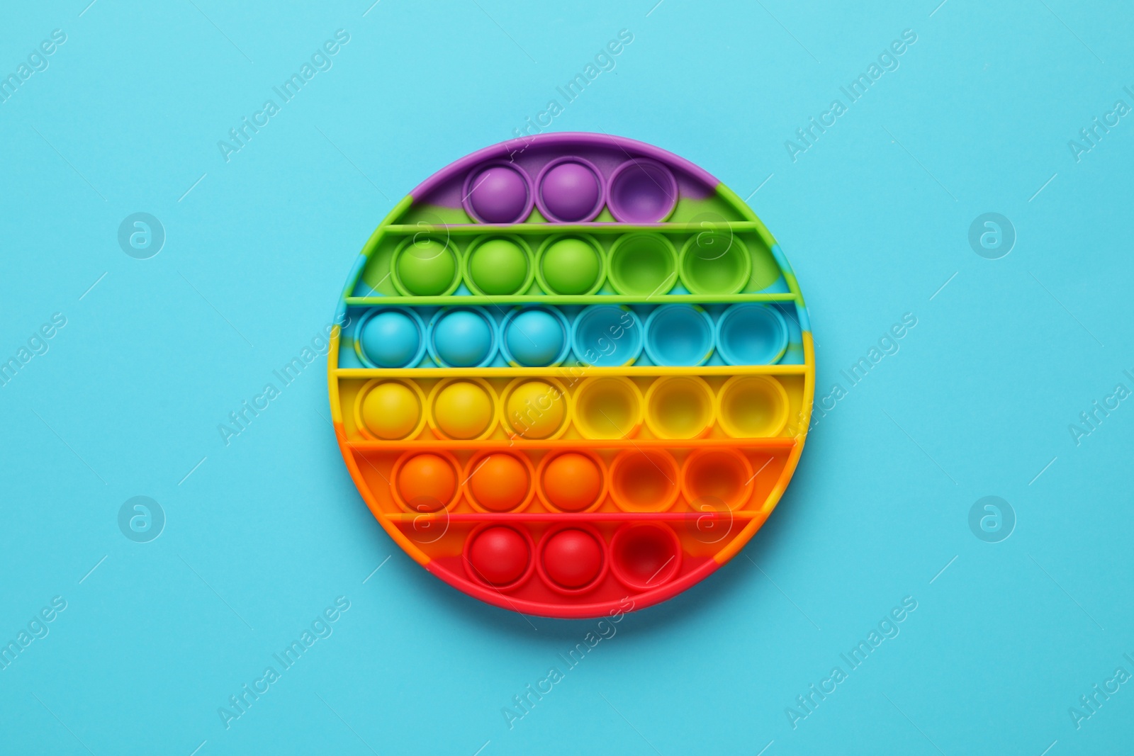 Photo of Rainbow pop it fidget toy on light blue background, top view