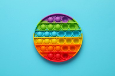 Rainbow pop it fidget toy on light blue background, top view