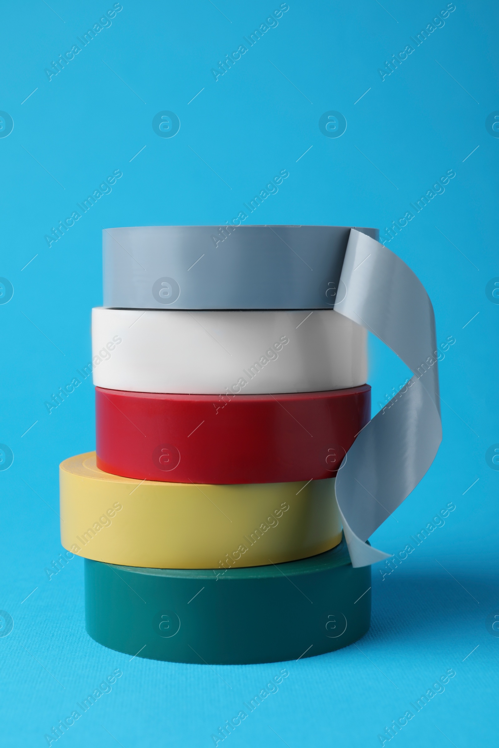 Photo of Colorful insulating tapes on light blue background