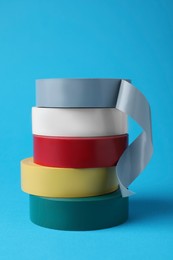 Photo of Colorful insulating tapes on light blue background