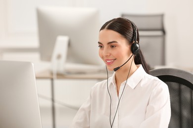 Hotline operator with headset working on computer in office