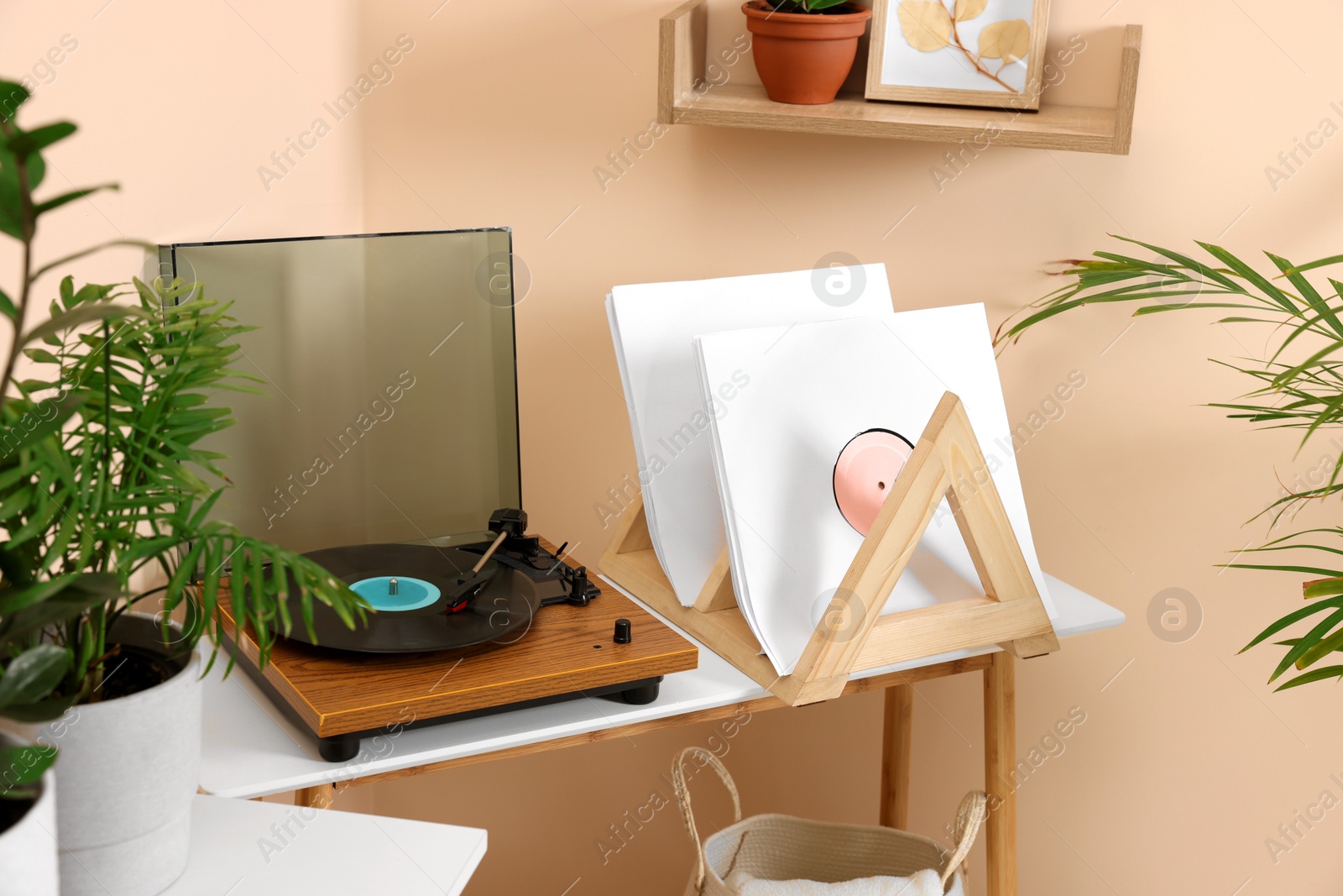 Photo of Stylish turntable with vinyl record on wooden table in room