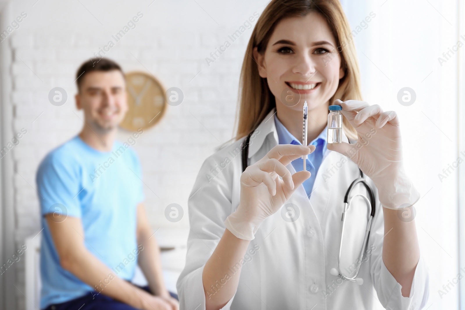 Photo of Doctor holding ampule with vaccine and syringe for patient in clinic